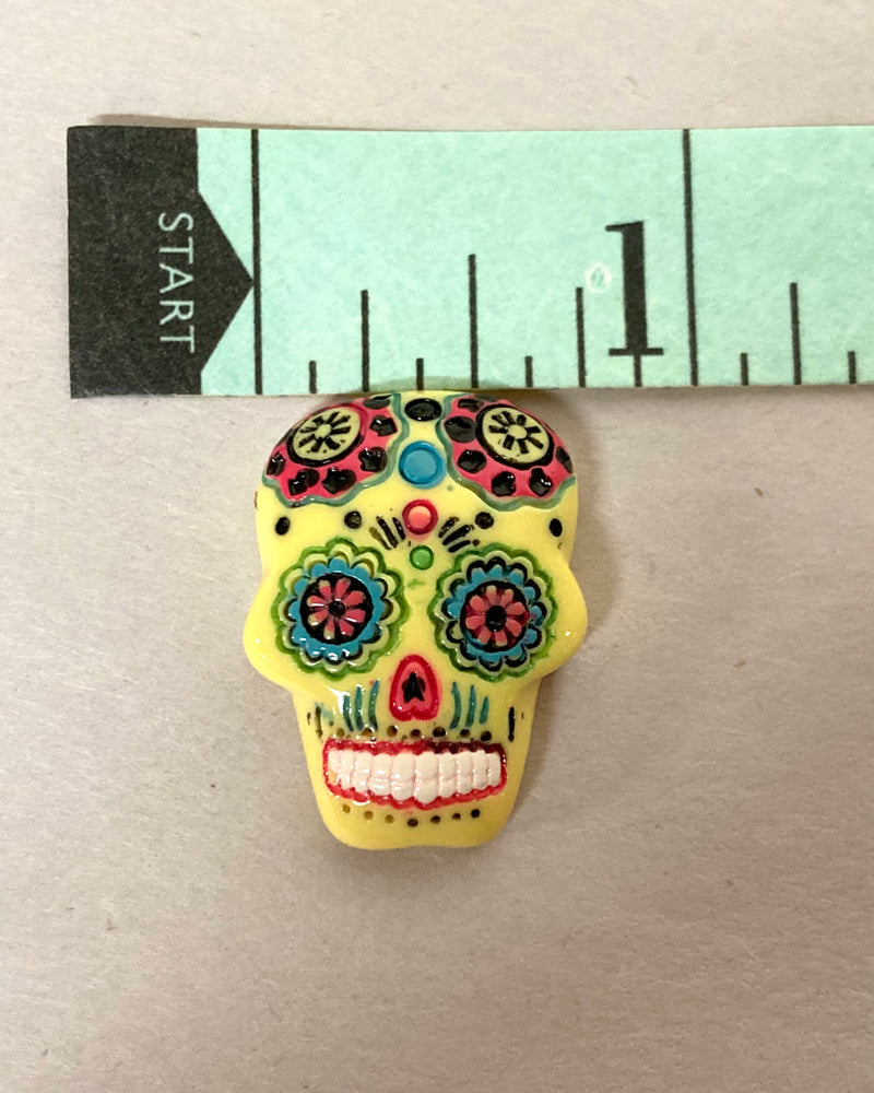 yellow sugar skull gem that is 1" long