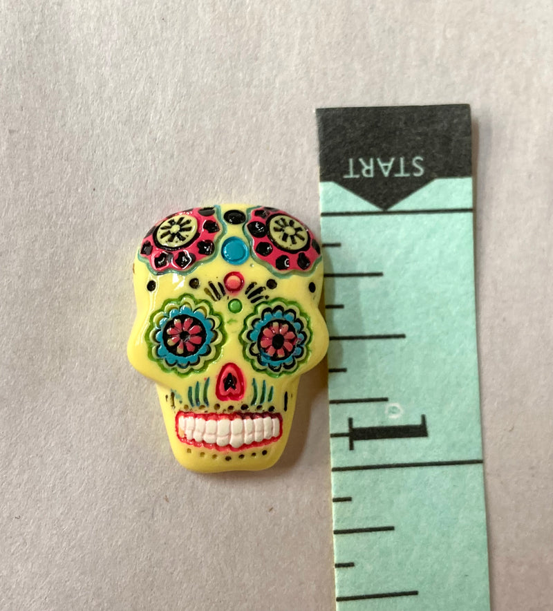 yellow sugar skull gem that is 1" long